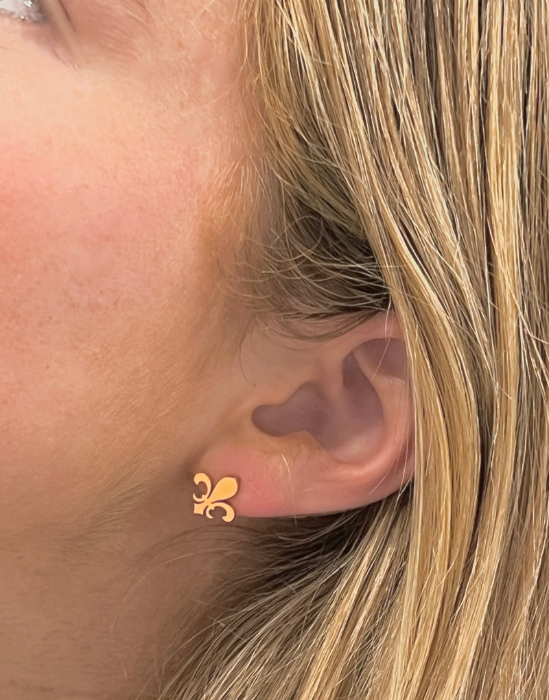 Fleur de lis stud earrings worn on ear